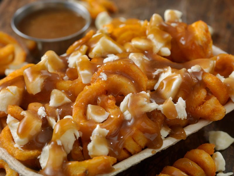 Curly Fry Poutine, with Brown Gravy and Cheese Curds in a Take out Container