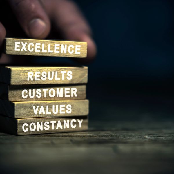 Stack of small blocks that say Excellence, Results, Customer, Values, Constancy