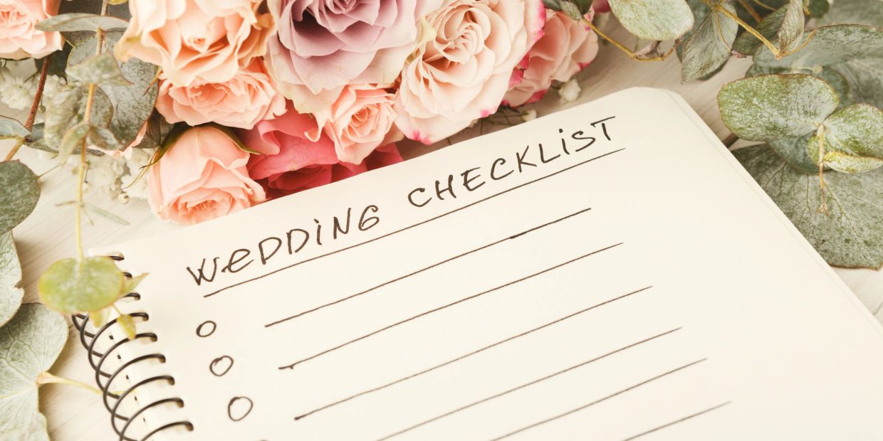 Notebook with a wedding checklist and roses.
