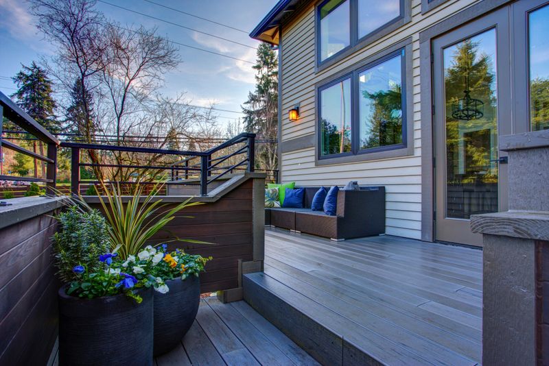 New construction home exterior boasts luxury oversized deck overlooking a Well-designed garden.