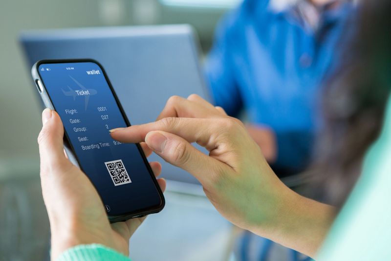 Unrecognizable woman uses a smart phone to make flight reservation.
