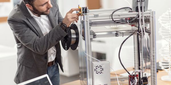 A technician aligning a 3D printer