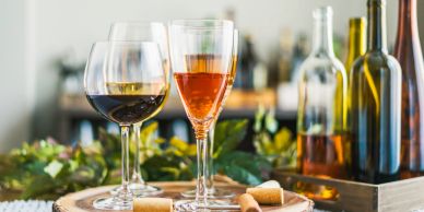 Two glasses of wine on a wooden surface.