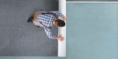 A man laying underlay before fitting a carpet 