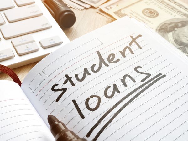 Student Loans written on lined paper in a black marker