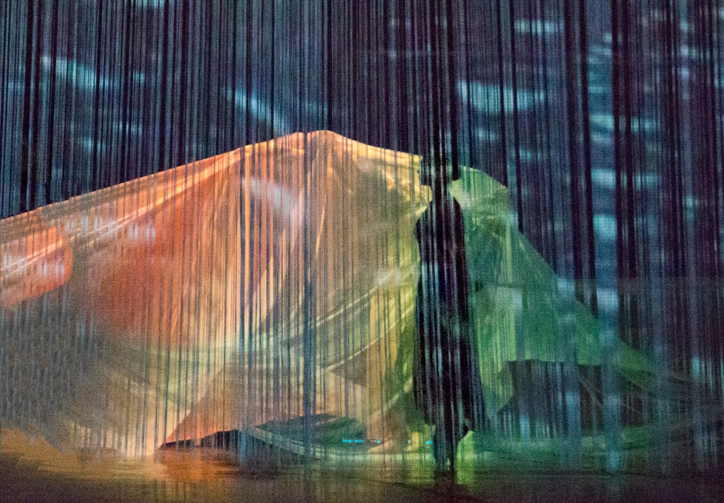 Silhouette behind colorful translucent scrim curtains creating a dreamy effect.
