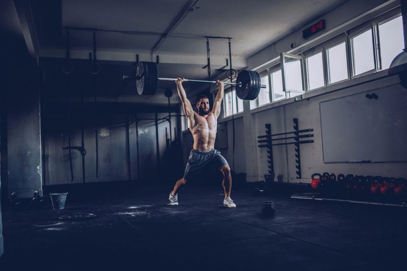 Bodybuilder exercising with barbells in the gym