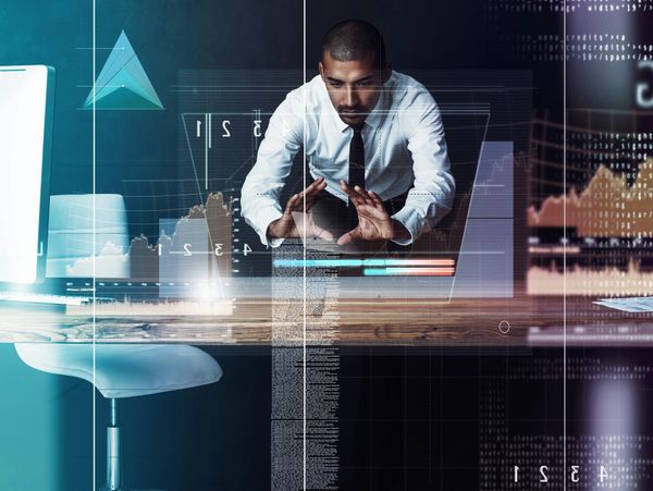 Businessman analyzing futuristic data and graphs on a transparent screen.