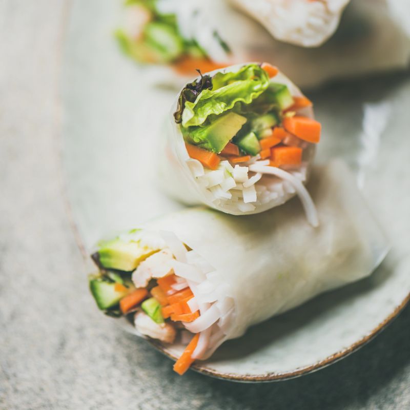 Shrimp and vegetable rice paper spring rolls with sauce and chopsticks on plate, selective focus, square crop. Asian cuisine, clean eating, vegetarian, dieting food concept