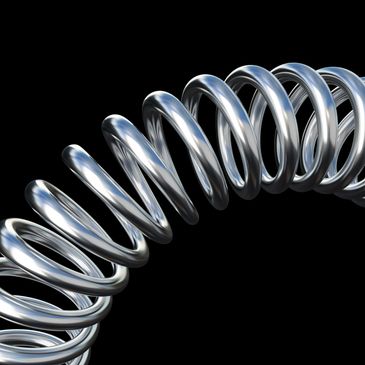 Close-up of a shiny metallic coil spring against a black background.