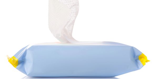 Blue pack of wet wipes with one wipe partially pulled out.