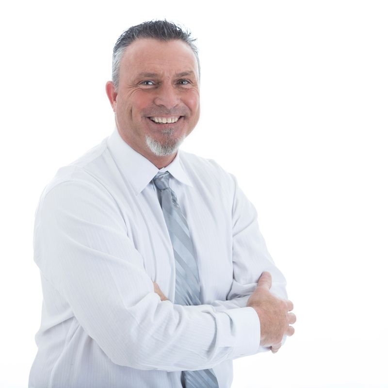 Handsome Caucasian mature businessman smiles confidently at the camera.