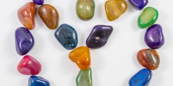Colorful polished stones arranged on a white surface.