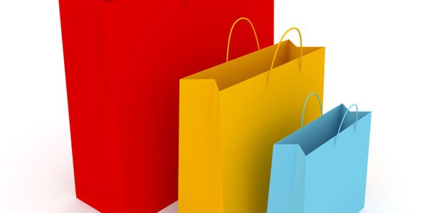 Colorful shopping bags in red, yellow, and blue with handles.