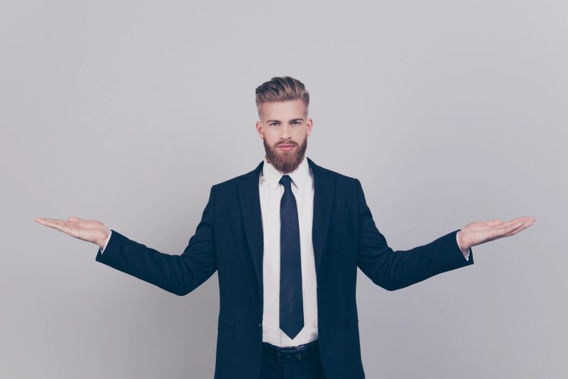Handsome serious attractive expert experienced qualified leader brutal pensive confident concentrated man wearing black suit with white shirt demonstrating empty blank place isolated gray background
