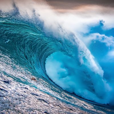 A powerful ocean wave curling and crashing with vibrant blue hues.