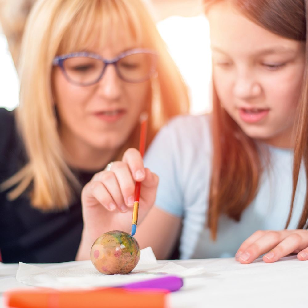 A child painting an Easter egg with autistic children support and healing ministry.