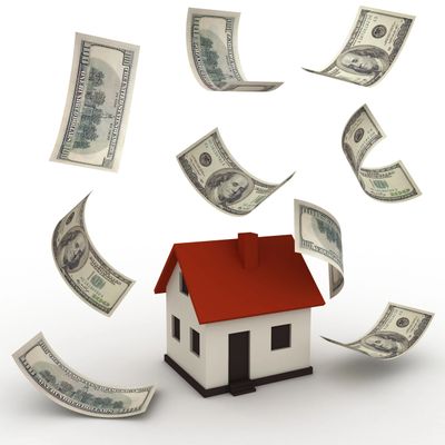 Model house surrounded by floating hundred-dollar bills symbolizing real estate investment.