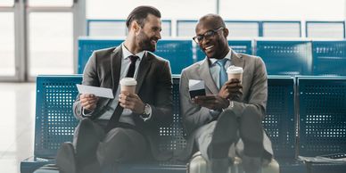 two business men talking while waiting for a flight
