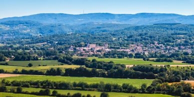 A scenic countryside village surrounded by green fields and hills.