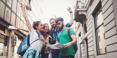 Group of friends excitedly navigating a city with a map.
