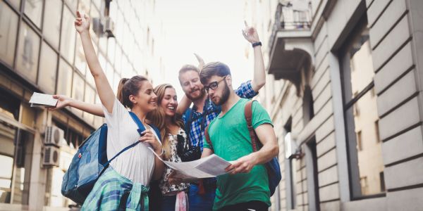 Group of friends excitedly exploring a city with a map.