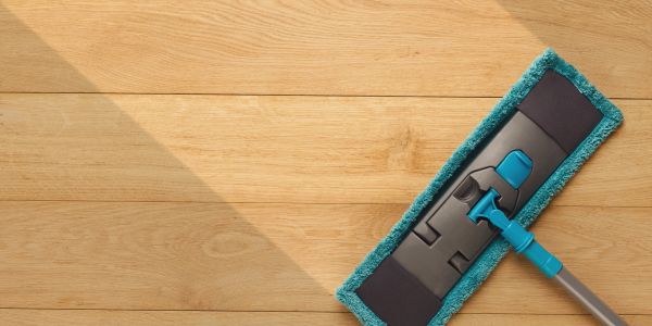 Blue mop cleaning a wooden floor.