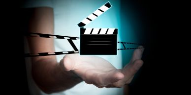 Film çekim klaketi ve film şeridi el üzerinde.
