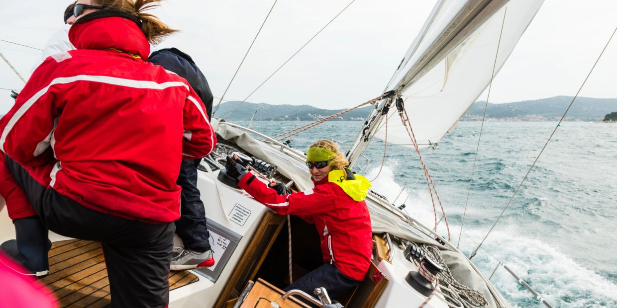 People sailing on a boat in rough waters.
