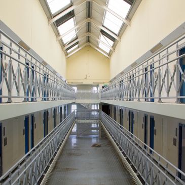 Two‑level prison cell block with skylights and walkways, showing secure correctional architecture.