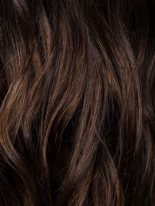 Close-up of dark brown wavy hair with subtle highlights.