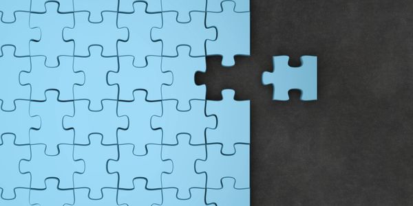 A blue puzzle with one piece missing and held nearby.