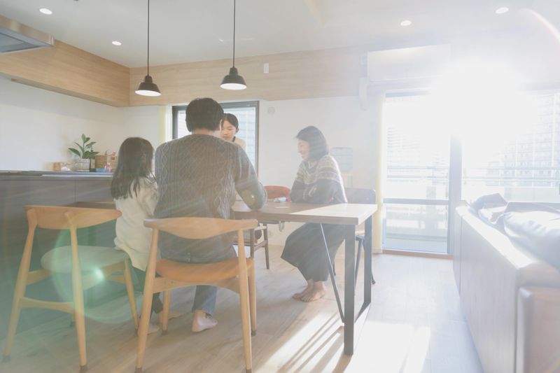 Asian family enjoying playing cards on the table.