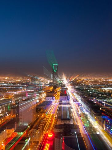 Night cityscape with zoom burst light effect, highlighting a tall building.