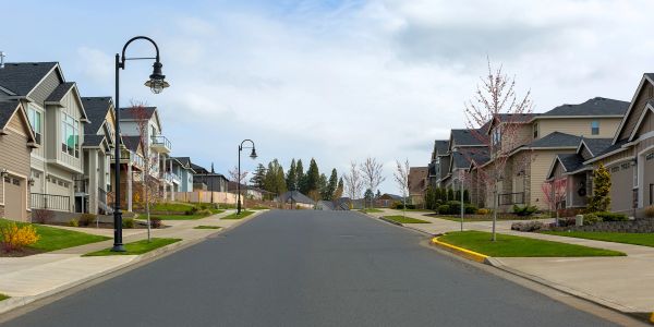 Quiet suburban street with houses and lampposts.