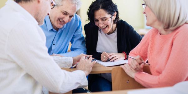Group of adults happily collaborating at a table.