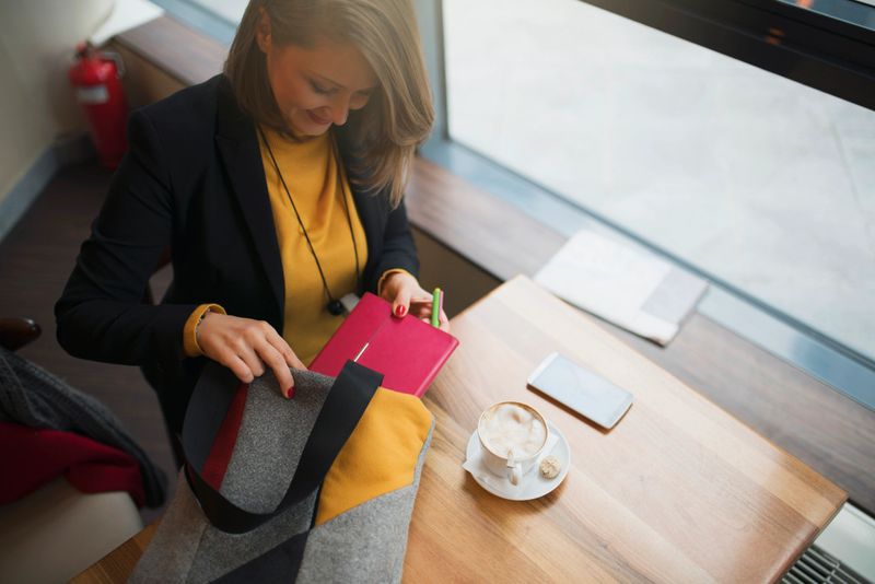 Directly above shot of a young businesswoman packing her bag.