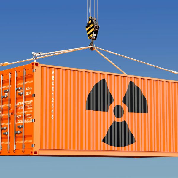 Orange container with a radiation hazard symbol being lifted by a crane.