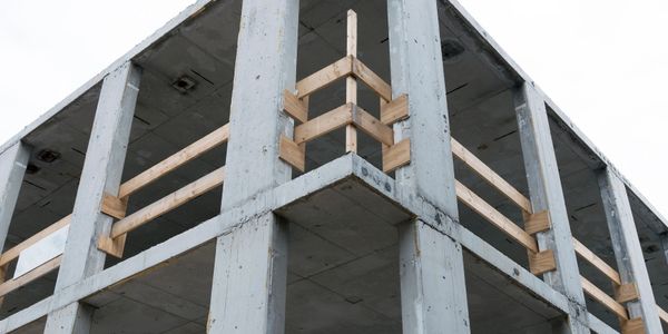 Concrete building structure with wooden safety railings under construction.