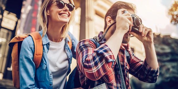 Happy travelers exploring with a map and camera in hand.