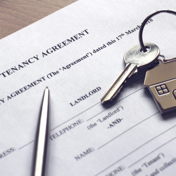 A tenancy agreement document with a pen and house-shaped keychain.
