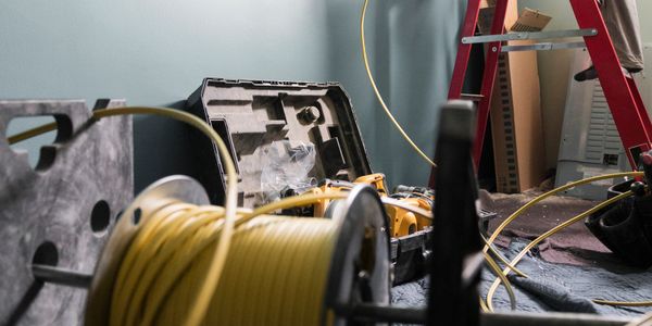 Close-up of a spool of yellow cable and tools in a workroom.