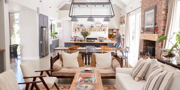 Bright, airy living room with cozy seating and rustic kitchen in the background.