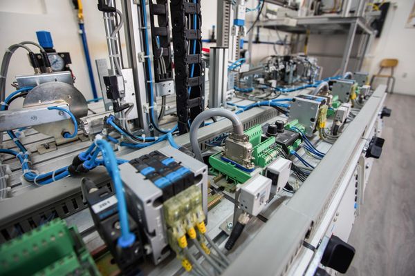 Technician testing electrical components inside a panel.