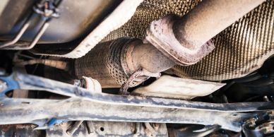 Car exhaust system with visible muffler and catalytic converter.