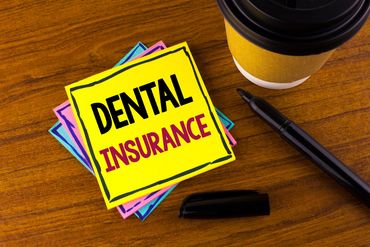 Sticky notes with "Dental Insurance" on a wooden table.