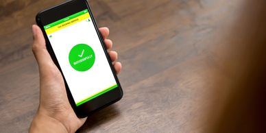 Person holding phone showing successful taxi booking confirmation.