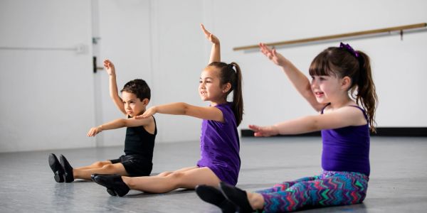 Children's hands spell out MINDFULNESS in colorful letters.