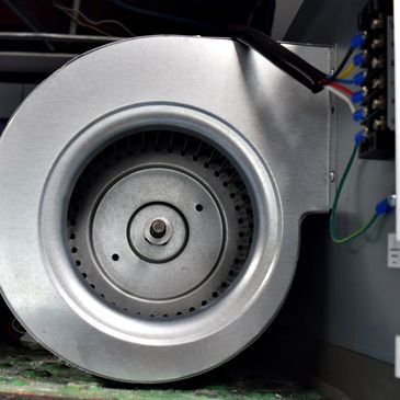 Close-up of a metallic centrifugal fan inside machinery.