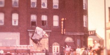 Firefighters respond to an emergency at a brick building with a fire truck outside.